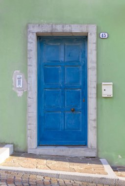 Yeşil renkli dış duvar turkuaz ön kapıya