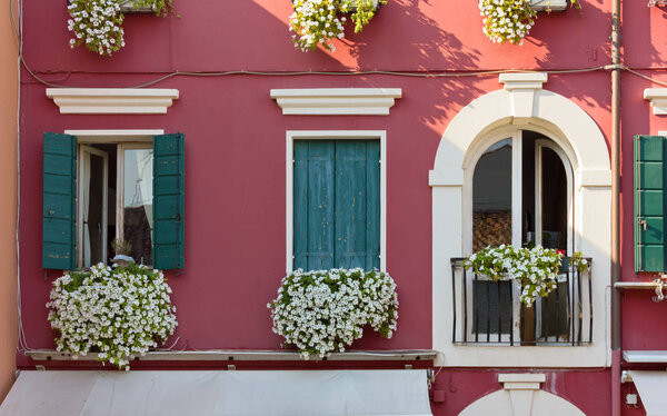 Facade of a traditional building in the venetian style decorated with flowers