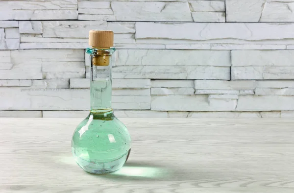 Cruet lleno de una bebida verde en una mesa de madera —  Fotos de Stock