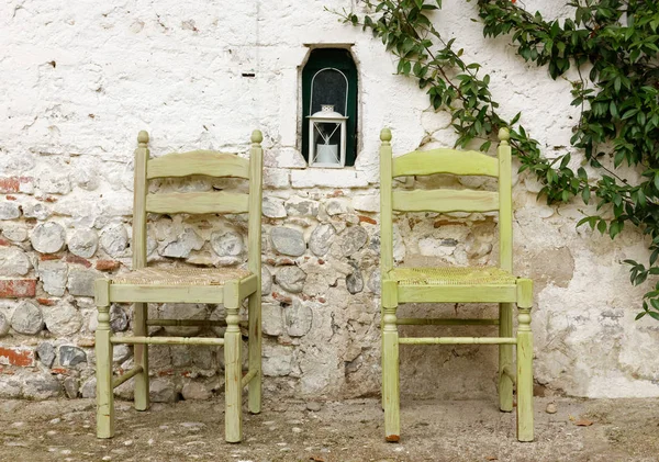 Δύο ξύλινες καρέκλες σε έναν εξωτερικό τοίχο — Φωτογραφία Αρχείου