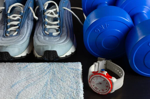 Zapatillas, sombrillas, una toalla y un reloj sobre un fondo oscuro — Foto de Stock