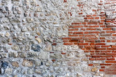 Kırmızı tuğlaları olan antik taş dış duvar.