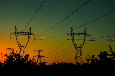 Gün batımında yüksek voltajlı elektrik hatları. Elektrik dağıtım istasyonu .