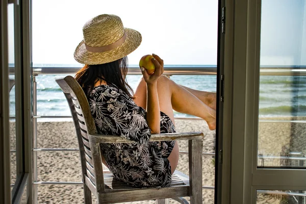 A girl with an apple looking to the sea