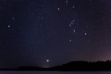 Orion ve küçük köpek takımyıldızları ve Sirius soğuk kış gecesi ufukta yukarıda.