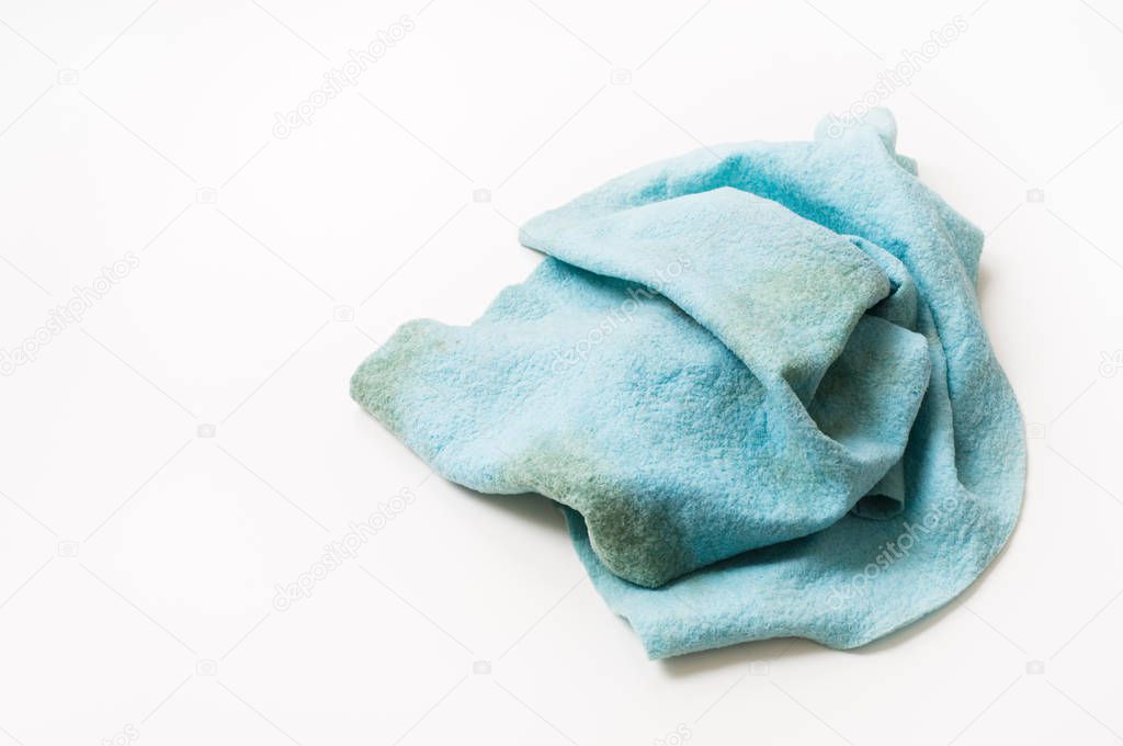 Dirty dish cloth on white table.