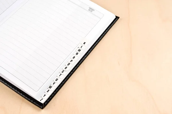 An open address book on wooden table.