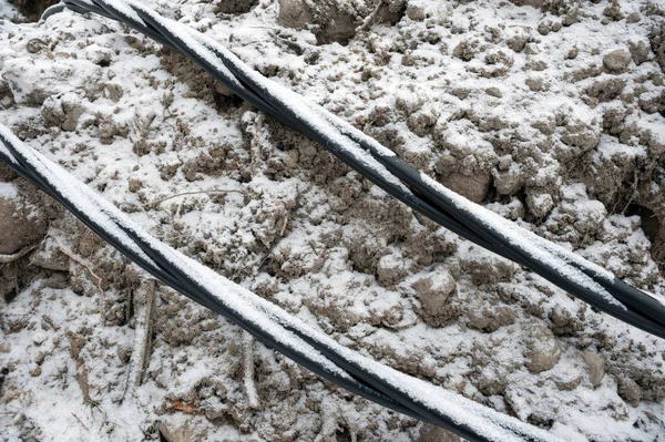 Laying a fiber optic and electricity cables in the frozen ground