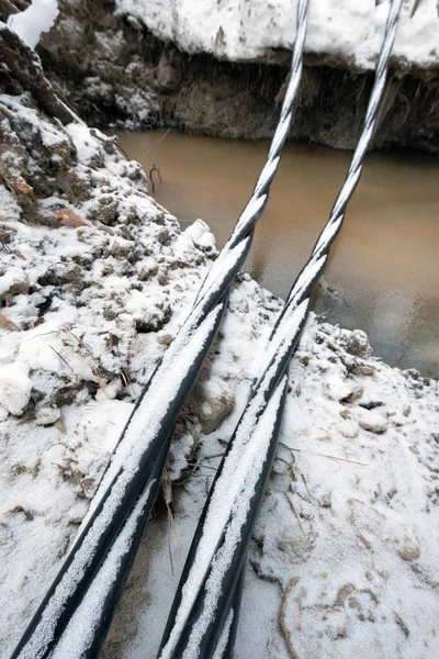 Laying a fiber optic and electricity cables in the frozen ground
