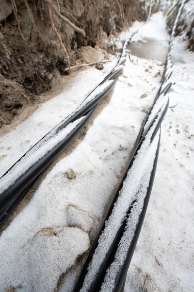 Laying a fiber optic and electricity cables in the frozen ground