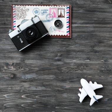 Tatil, iş seyahat, seyahat, gezi, tatil planlama kavramı. Seyahat zamanı, dinlenmek için zamanı. Retro kamera, beyaz model uçak, zarf için seyahat, ahşap arka plan üzerinde pusula.