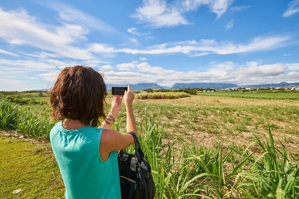 A female tourist shooting sugar cane fields or Reunion Island (S