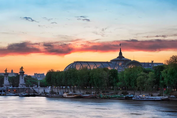 Panoramic view of the the Alexander III Bridge at dusk with Grand Palais (Great Palace) on the background. It's a deck arch bridge, regarded as the most ornate, extravagant bridge in the city. — Stock Photo, Image