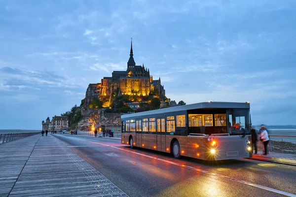 MONT SAINT MICHEL, FRANÇA - 26 de setembro de 2017: Vista sobre a famosa ilha do Monte Saint Michel com ônibus de transporte turvo projetado para transportar turistas — Fotografia de Stock