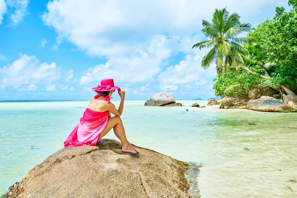 Kobieta turysta z sarong na tropikalnej plaży pod palmą, Anse a La Mouche, Mahe, Seszele — Zdjęcie stockowe