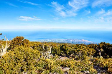 Mado, La Runion 'dan panoramik bir manzara, uzaktaki adaların nefes kesici manzarasını sunuyor, yemyeşil uçurumlar ve ufka karışan engin mavi okyanuslar..