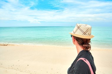 Meraklı iranja 'nın beyaz kumsalında yürüyen kadın turist.