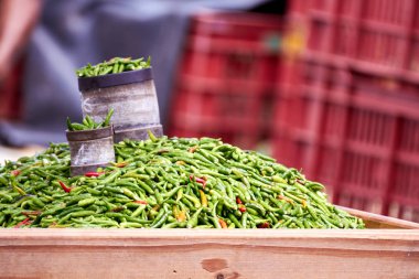 La Runion açık hava pazarında taze yeşil biberlerle dolu bir tezgah, adanın zengin aşçılık mirasını ve taze ürün kültürünü ön plana çıkarıyor.