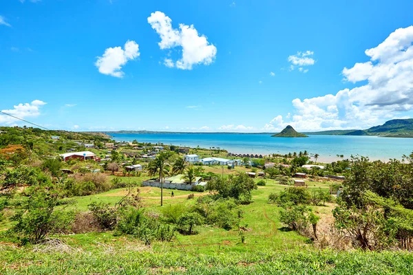 Madagaskar 'daki Diego Suarez' in baş döndürücü körfezi, Sugarloaf Dağı, canlı turkuaz suları ve geleneksel sahil evleri yer alıyor. Turizm ve kültürel hikaye anlatmak için ideal sakin bir tropikal manzara..