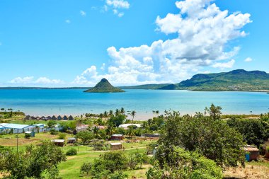 Diego Suarez, Madagaskar 'daki körfezin panoramik manzarasında ikonik Sugarloaf dağı, turkuaz sular ve geleneksel sahil evleri yer alıyor. Seyahat, kültür ve tropikal manzaralar için mükemmel bir sahne..