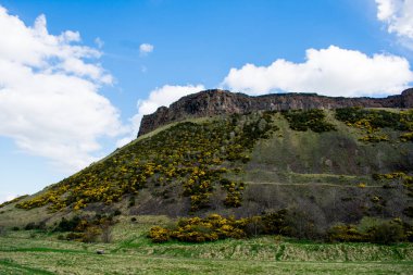 Bulutlu gökyüzü güneşli bir Edinburgh üzerinde seyir kaya