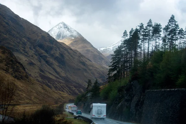 Uma Linha Carros Vans Dirigindo Uma Estrada Molhada Através Montanhas — Fotografia de Stock