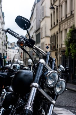 A yakın çekim bir Arnavut kaldırımlı sokakta yağmur damlaları ile bir motosiklet