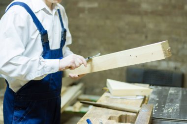 Tahta işleme. Kendine güvenen genç erkek marangoz atölyesini ahşap ile çalışma