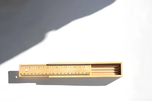 Pencils in a pencil case are on the table in bright daylight. Natural unpainted wood. Eco-friendly materials — Stock Photo, Image