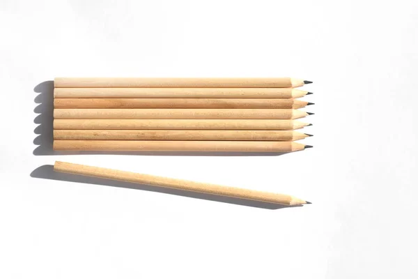 8 blyertspennor finns på bordet i ljust dagsljus. Naturligt omålat trä. Miljövänliga material. Inte som alla andra — Stockfoto