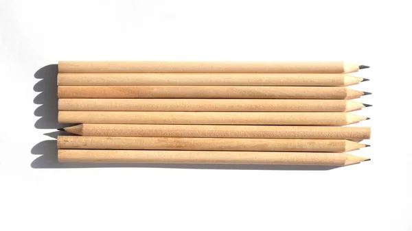 Veel potloden staan op tafel bij helder daglicht. Natuurlijke ongeverfd hout. Milieuvriendelijke materialen. Niet zoals alle anderen — Stockfoto