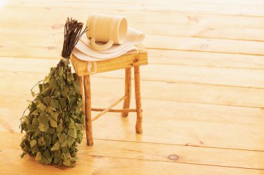 Saunada şımartılmak ve dinlenmek. Buhar odası, ahşap mobilyalar, banyo süpürgesi ve kupadaki su için aksesuarlar. Spase kopyala