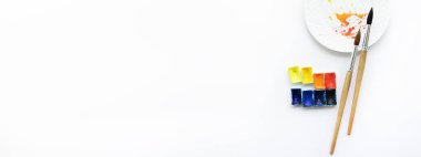 Suluboya, fırça ve palet beyaz arka planda, üst manzara. Hobileri ve keyfi yerinde.