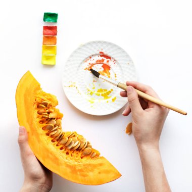 Ellerinde bir parça balkabağı. Adam suluboya bir balkabağı boyuyor. İyi ruh hali kavramı