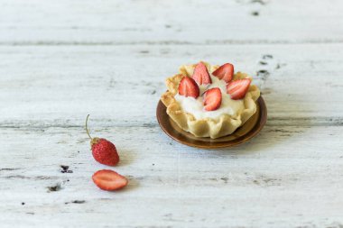 Tereyağlı tart ve beyaz ahşap arka planda taze çilek. Yatay yönelim