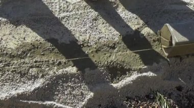 Beton kaldırım taş ve metal ile dize kullanarak alt düzeye kaldırım inşaat sahasında kazıklar.