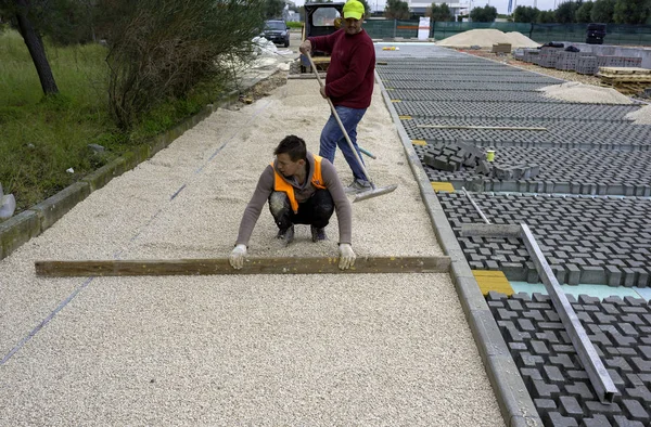 Robotnik Budowlany Układa Blokady Betonu Nawierzchniowego Blachę Włókniny Piasku Pościelowego — Zdjęcie stockowe