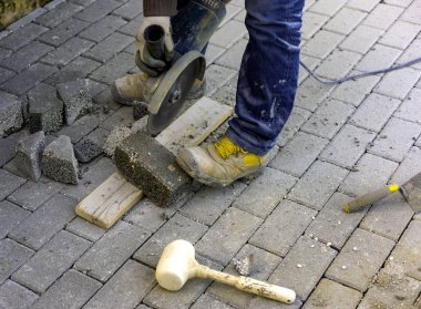 Çalışan bir döşeme boyutu için kendi kendine kilitlenen kaldırım tamamlamak için bir elektrik değirmeni ile keser