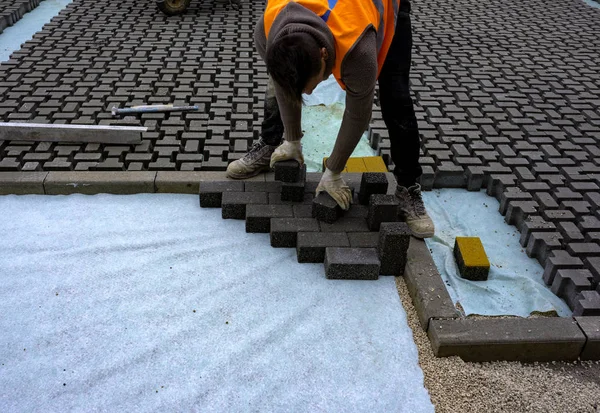 Robotnik Budowlany Układa Blokady Betonu Nawierzchniowego Blachę Włókniny Piasku Pościelowego — Zdjęcie stockowe
