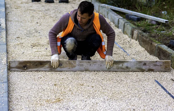 Stavební Dělník Pokládající Propletený Dlažební Beton Prostěradlo Netkané Podestýlky Písku — Stock fotografie