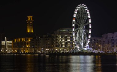 Gece panoramik aydınlatmalı giant Ferris wheel Waterfront bari. Apulia, İtalya.