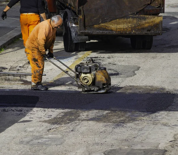 Compactor finishing the last phase of laying new asphalt to patch a bump in the road. — Stock Photo, Image