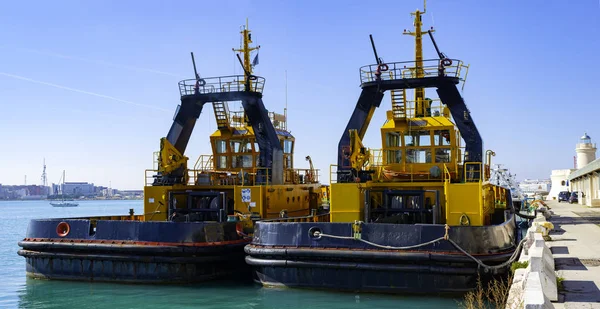 Two tugs boat stands ready to help ships in the port of Bari