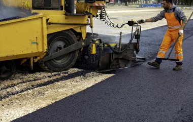 Makine operatörü asfalt yaymak için, asfalt kaldırım ayarlamak için kontrol paneli müdahale