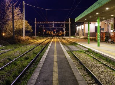 Conversano, İtalya - 27 Mart 2016: kapalı akşam tren istasyonu, raylar ve kırmızı ışık