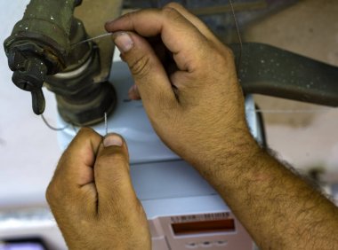 İşçi mührü boru ve gaz sayacının arasına yerleştiriyor. Seçici odak