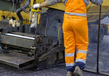 Asfalt paver ile inşaat sırasında 160 derecenin üzerindeki sıcaklıklara ısıtılan. Yol özel ekipman yolu döşeme.