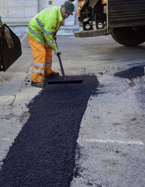 Asfalt paver ile inşaat sırasında 160 derecenin üzerindeki sıcaklıklara ısıtılan. Yol özel ekipman yolu döşeme.