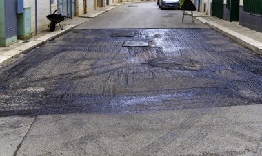 bituminous emulsion sprayed on the surface before starting the laying of the asphalt for road repair clipart