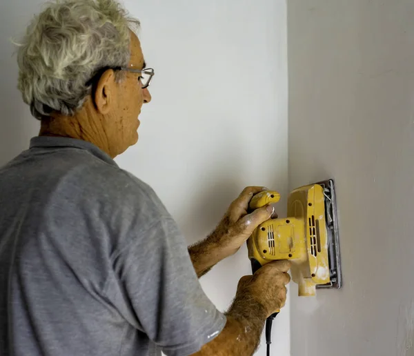 Trabajador Con Una Lijadora Orbital Suaviza Una Pared —  Fotos de Stock